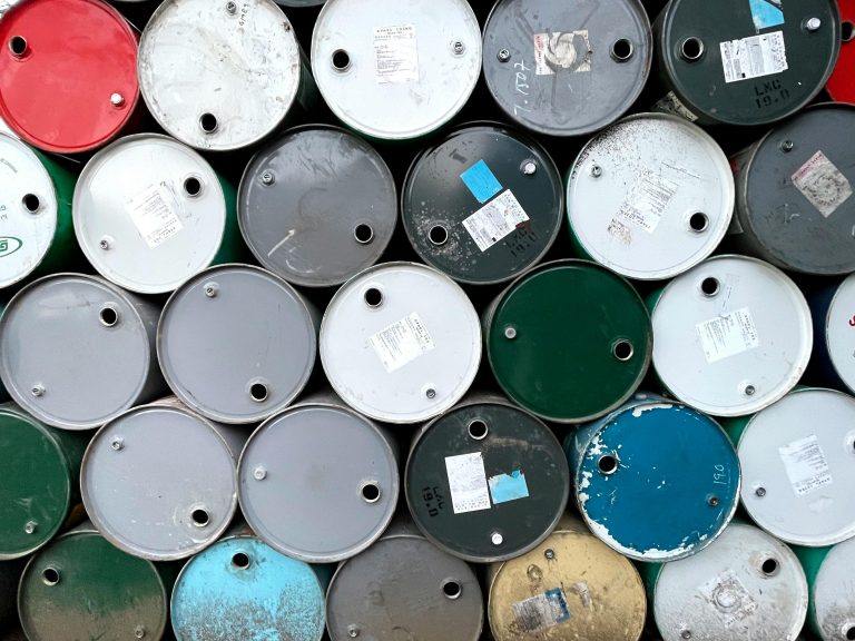Close-up of colorful oil barrels stacked outdoors in Mandalay, Myanmar.